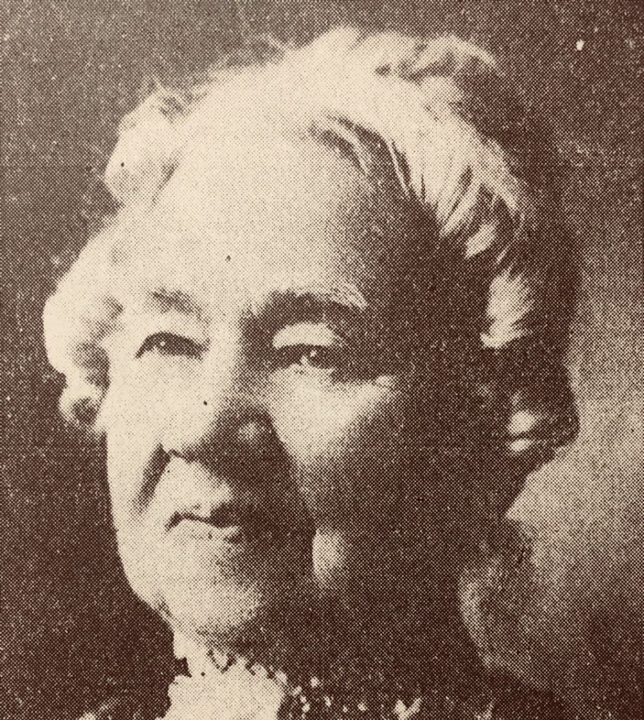 Photograph of Betsey B. Winslow - headshot of older woman, in sepia tones. Woman has an up-do and light-colored ring curls framing her face.