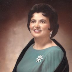 Color Painting Of Maria Alves -- A Woman With Short Black Hair Wearing A Light Green-blue Dress, Black Shawl, And Jeweled Brooch And Earrings.