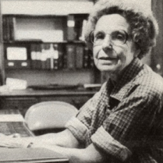 Photograph Of Mabel Knipe - And Older Woman With Short Curly Hair, Round Glasses, And A Rolled Up Plaid Shirt