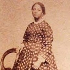 Photograph Of Abolitionist Jane Jackson - A Woman Standing With Her Dark Hair Pulled Back. She Is Wearing A Long, Polka Dot Dress