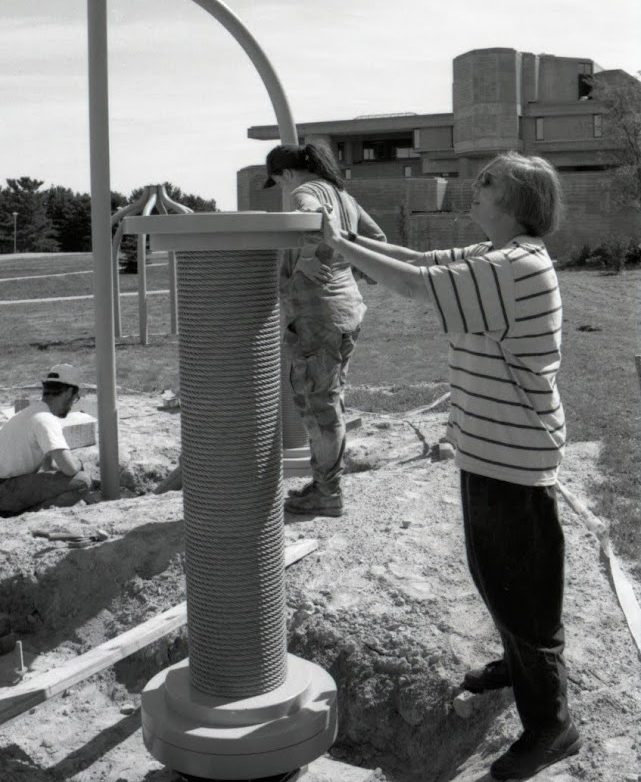profile photograph of Nancy Holt standing facing a pillar